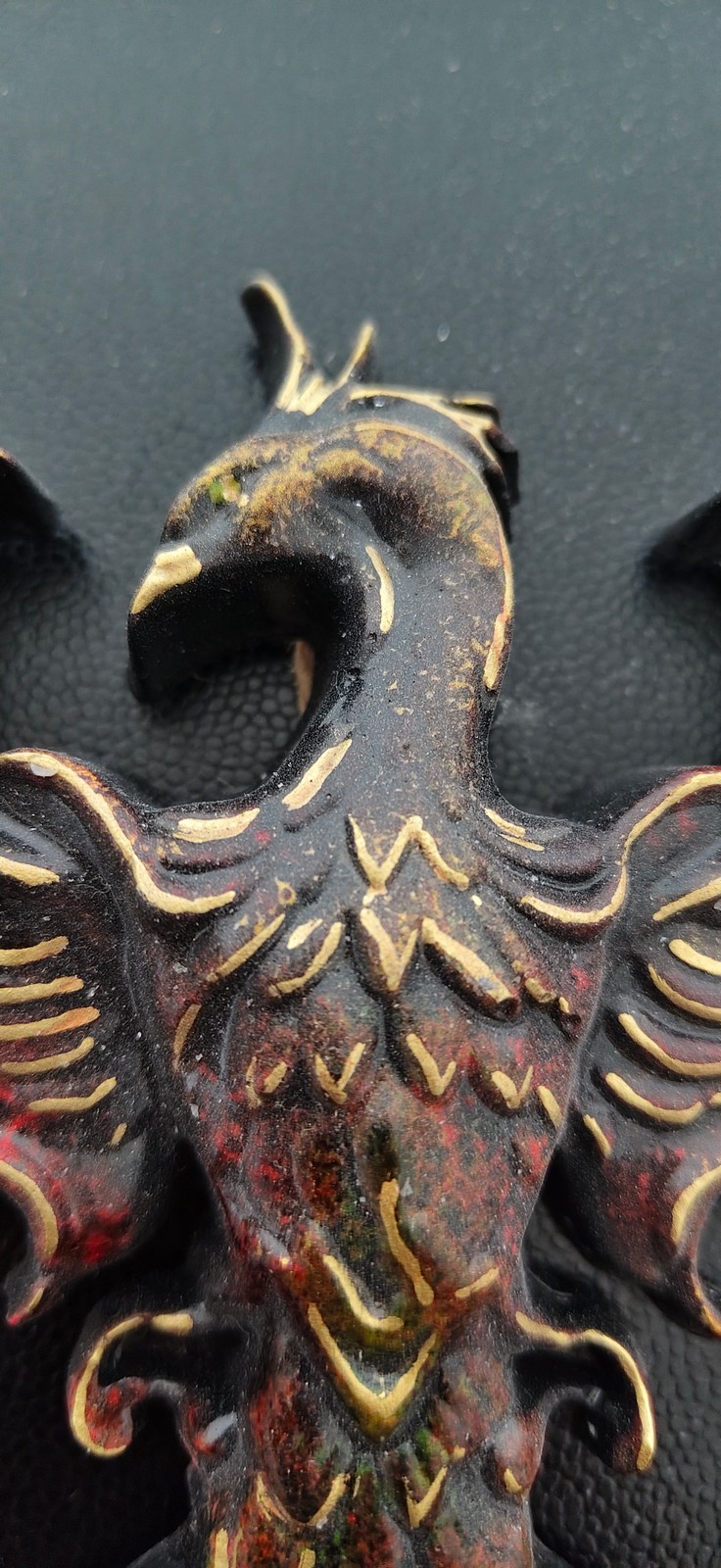 Detailní záběr na ručně malovanou reliéfní dekoraci Mystický Fénix z Keraflotu s výraznou patinou a propracovaným peřím.